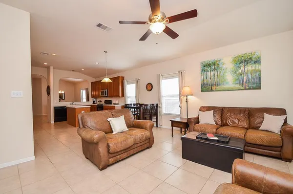 a living room with furniture and a view of kitchen