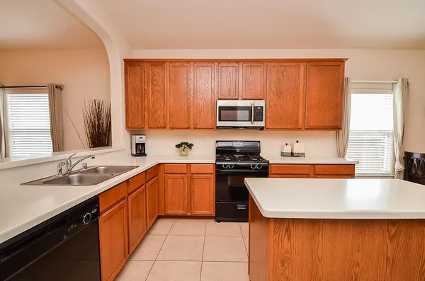 a kitchen with stainless steel appliances a stove sink microwave and cabinets