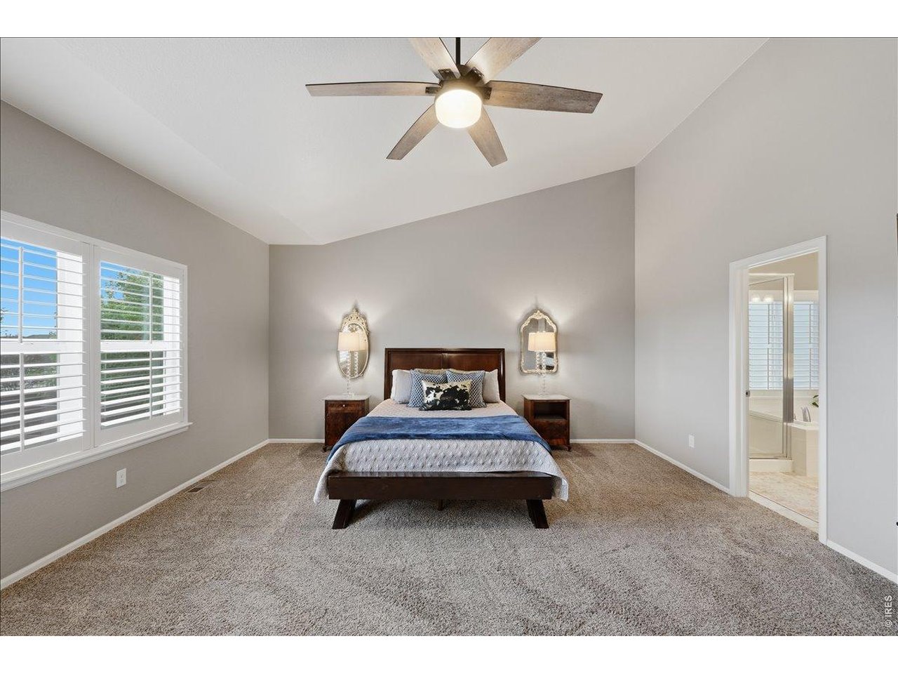 6096 Story Road Timnath, CO 80547 - Photo 18 of 50 a bedroom with a bed and a chandelier