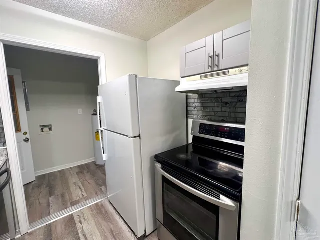 a kitchen with a refrigerator and a stove