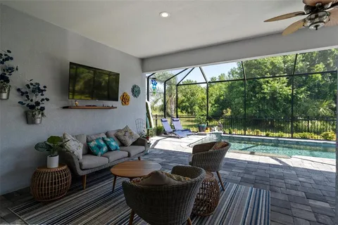 a view of a white house with a yard and large trees