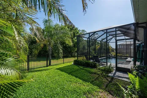 a view of a swimming pool with lawn chairs and a big yard