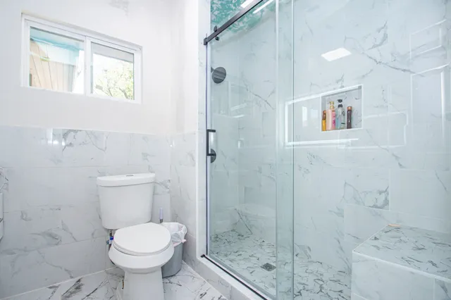 a bathroom with a shower toilet and sink