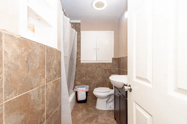 a bathroom with a toilet sink and mirror