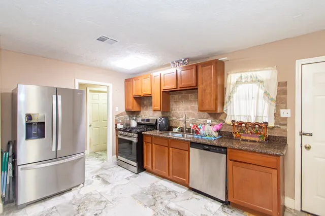 a kitchen with a sink stove and refrigerator