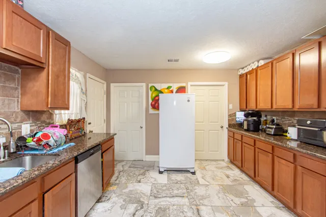 a kitchen with stainless steel appliances granite countertop a refrigerator sink and cabinets