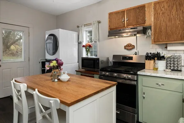 a kitchen with granite countertop a stove a sink and cabinets