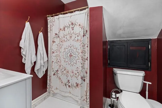 a bathroom with a toilet and a shower curtain