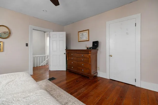 a view of a bedroom with wooden floor and cabinet