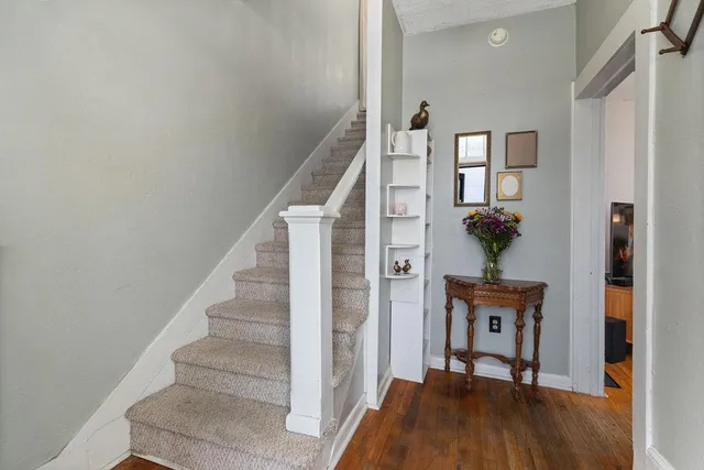 a view of entryway and hall with wooden floor