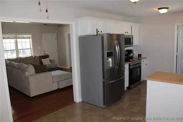 a metallic refrigerator freezer sitting in a kitchen