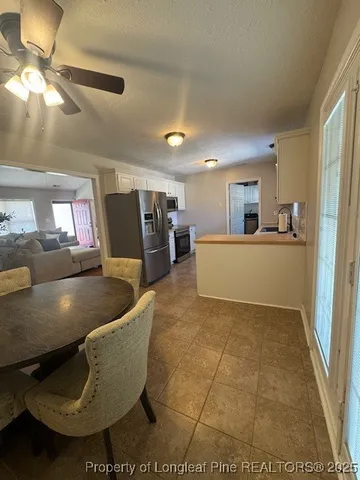 a living room with couches and kitchen view with wooden floor