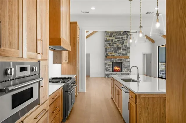 a kitchen with stainless steel appliances granite countertop a sink stove and refrigerator