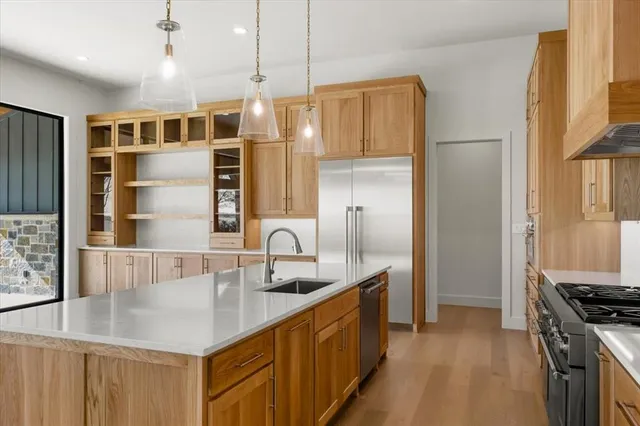 a kitchen with stainless steel appliances granite countertop a sink a stove and a refrigerator