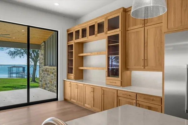 a kitchen with stainless steel appliances wooden floor and a large window