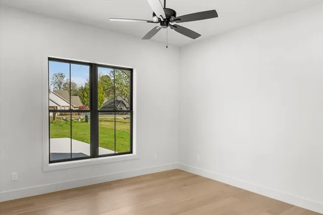 an empty room with a window and ceiling fan