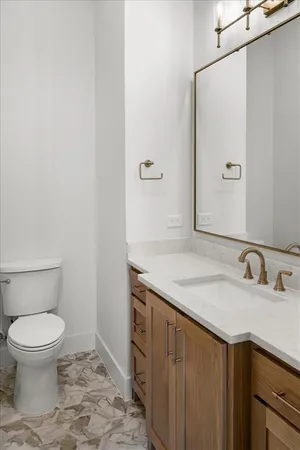 a bathroom with a granite countertop sink a toilet and a mirror