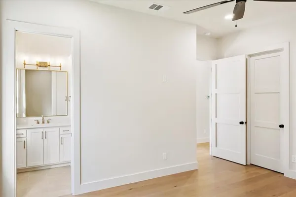 an empty room with wooden floor and mirror