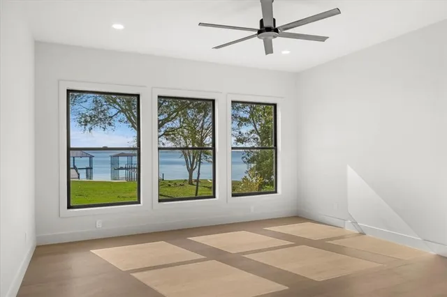 a view of an empty room with a window and a kitchen