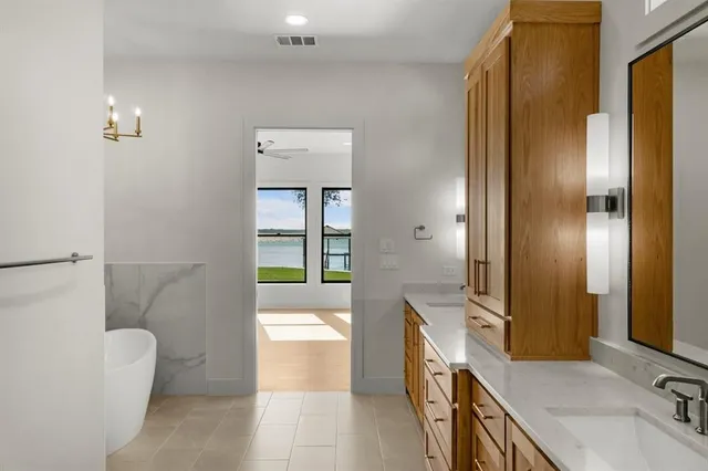 a bathroom with a tub sink and mirror