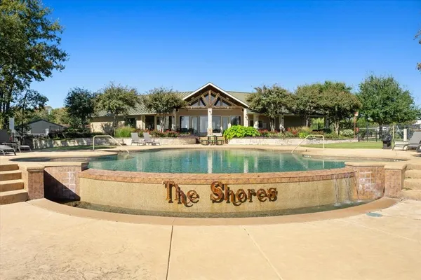 a view of swimming pool with outdoor seating and house in the background