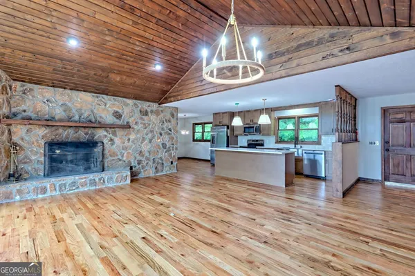a kitchen with a sink a chandelier and wooden floor