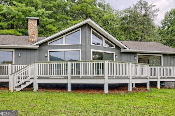 a view of a house with a yard and deck