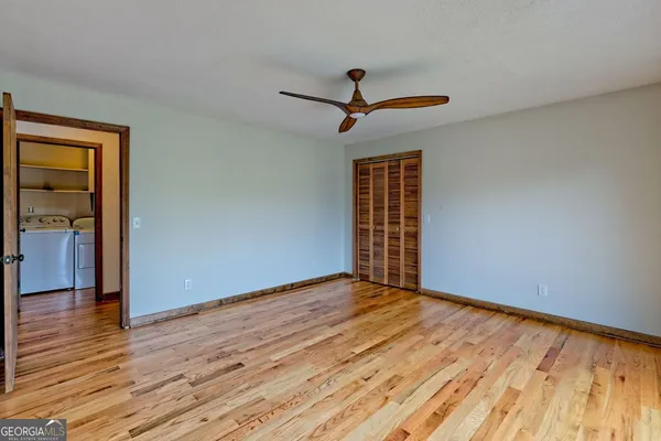 a view of a hallway with wooden floor and staircase