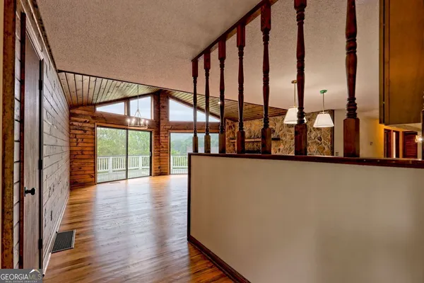a view of a hall with a fireplace and wooden floor