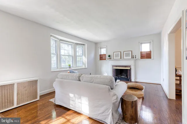 a living room with furniture a fireplace and a window