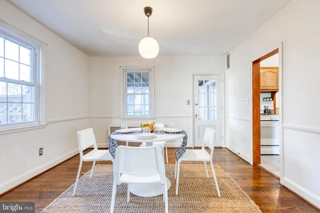 a dining room with furniture a rug and wooden floor