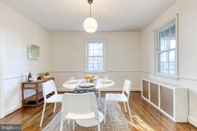 a view of a dining room with furniture a rug and wooden floor