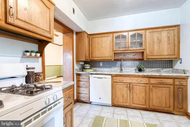 a kitchen with stainless steel appliances granite countertop a stove sink and cabinets