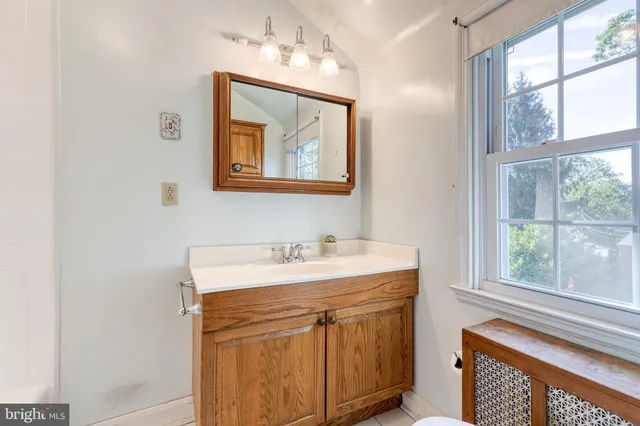 a bathroom with a sink vanity and a window