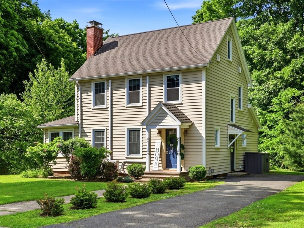 a front view of a house with a yard and potted plants