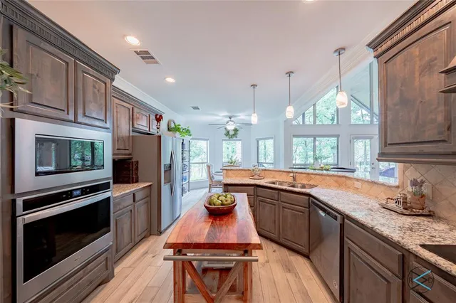 a kitchen with stainless steel appliances granite countertop a stove a sink and a microwave