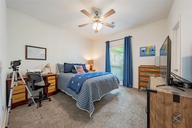 a spacious bedroom with a bed and a flat screen tv