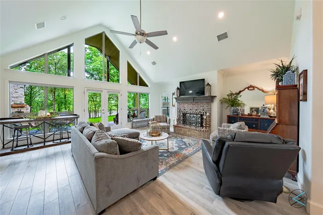 a living room with furniture a fireplace and a floor to ceiling window