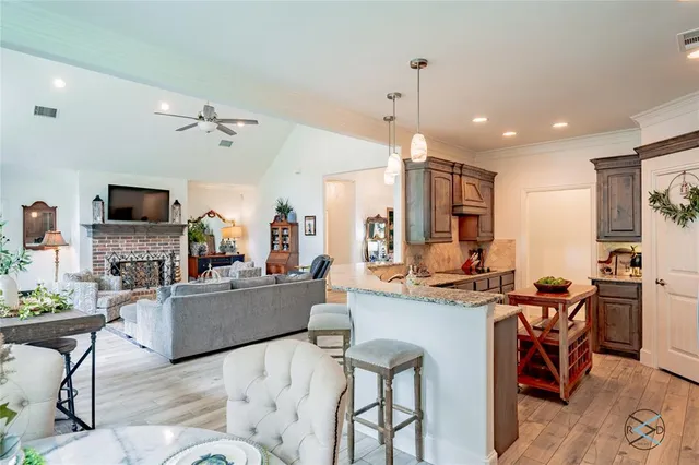 a living room with stainless steel appliances kitchen island granite countertop furniture and a flat screen tv