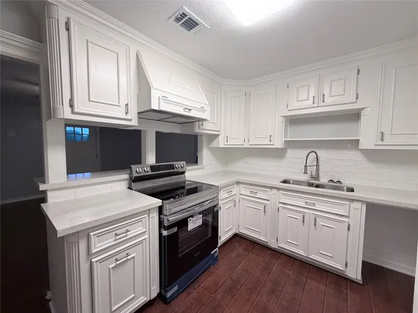 a kitchen with cabinets stainless steel appliances and sink