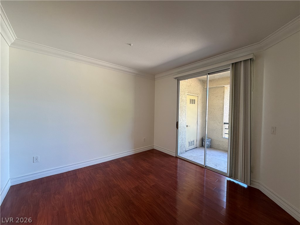 210 East Flamingo Road, Unit 126 Las Vegas, NV 89169 - Photo 7 of 16 Rich hardwood floors complement elegant crown molding in this versatile living space, opening to a private balcony.