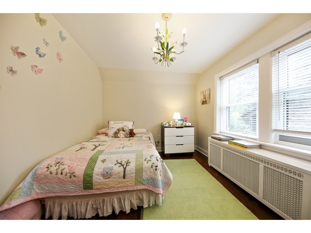 719 Arlington Road Riverside, IL 60546 - Photo 16 of 22 a bedroom with a bed and a chandelier