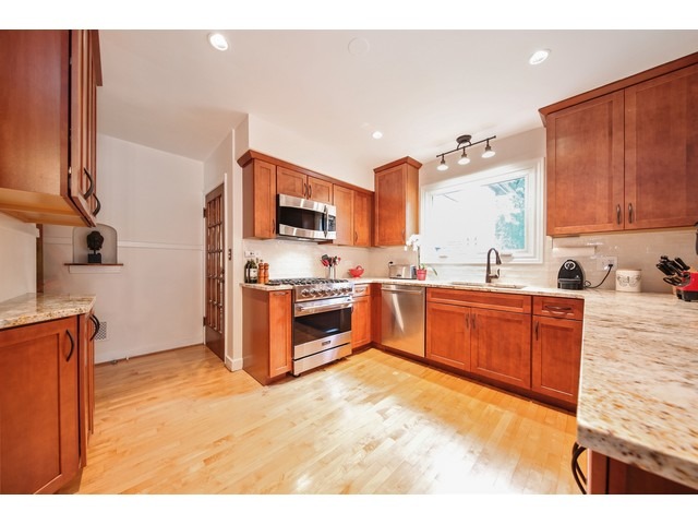 719 Arlington Road Riverside, IL 60546 - Photo 6 of 22 a kitchen with stainless steel appliances kitchen island granite countertop a stove top oven a sink dishwasher and granite countertops with wooden floor