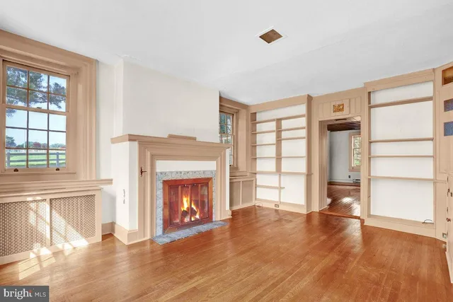 a view of an empty room with a fireplace and a window