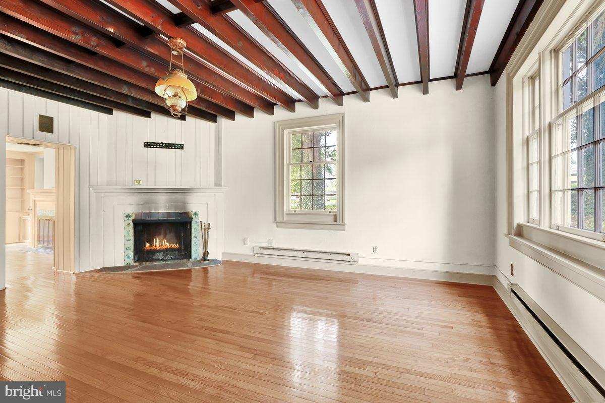 284 Old Mill Road Parkesburg, PA 19365 - Photo 18 of 50 a view of an empty room with wooden floor fireplace and a window