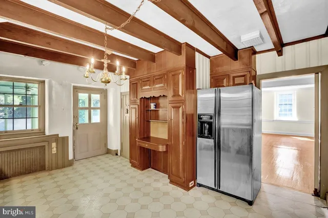 a view of a kitchen with a refrigerator and windows