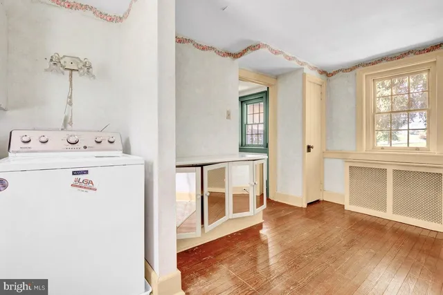 a view of a hallway with wooden floor and entryway