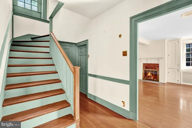 a view of a hallway with wooden floor and staircase