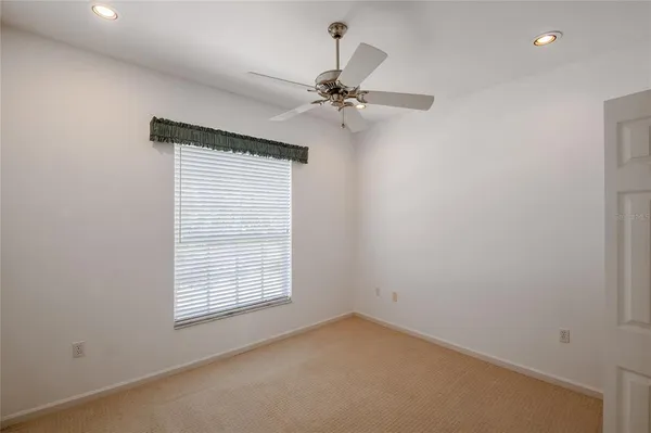 an empty room with a window and a fan