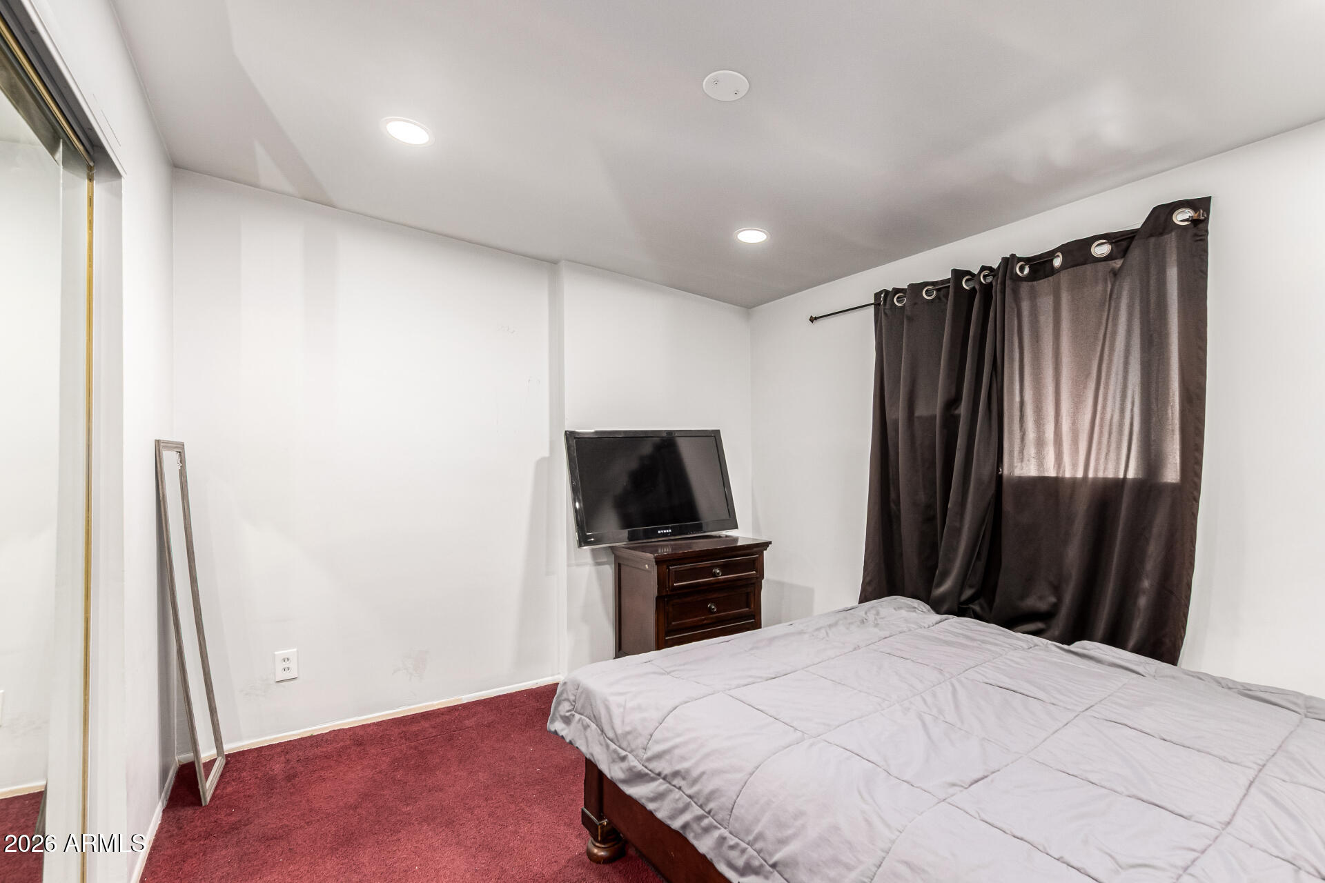 8218 West Osborn Road Phoenix, AZ 85033 - Photo 20 of 27 a bedroom with a bed and a flat tv screen